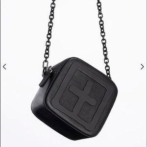 Kube mini bag is made of calf leather with chain straps. Embossed T box logo
